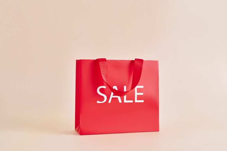 red paper bag with sale sign